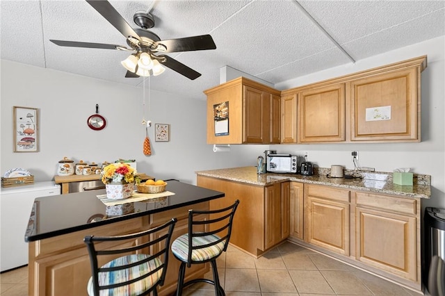 2120 Greentree Rd Unit 610E, Pittsburgh, PA 15220 - kitchen featuring a ceiling fan, light tile patterned flooring, a center island, and a kitchen breakfast bar