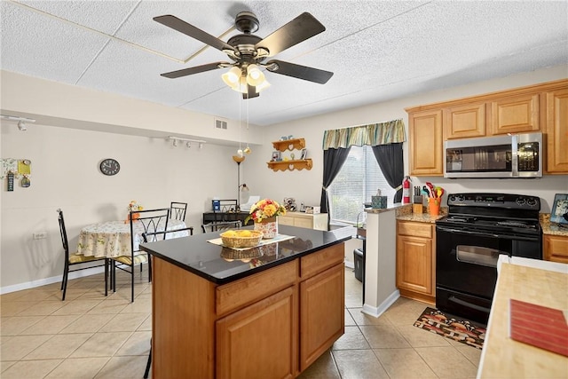 2120 Greentree Rd Unit 610E, Pittsburgh, PA 15220 - kitchen with stainless steel microwave, black electric range oven, light tile patterned flooring, a kitchen island, and a ceiling fan