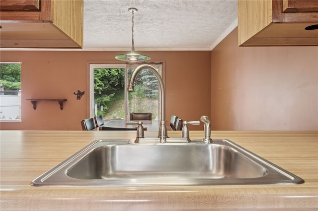 437 Shady Ridge Dr, Monroeville, PA 15146 - kitchen with a textured ceiling, crown molding, plenty of natural light, light countertops, and hanging light fixtures