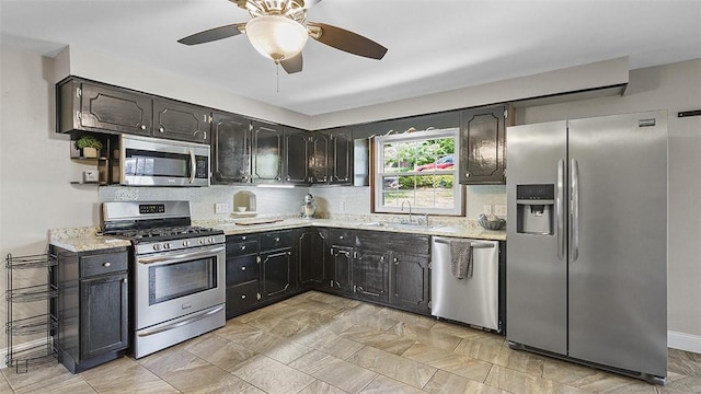 900 N Whitmore Rd, North Huntingdon, PA 15642 - kitchen featuring appliances with stainless steel finishes, a ceiling fan, backsplash, and light stone counters