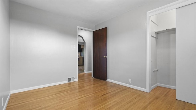 900 N Whitmore Rd, North Huntingdon, PA 15642 - unfurnished bedroom featuring light wood-style floors, arched walkways, and a closet