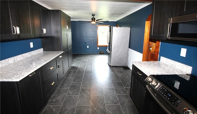 216 Duffy Dr, Moon/Crescent Twp, PA 15108 - kitchen with stainless steel appliances, ceiling fan, a wainscoted wall, and dark cabinets