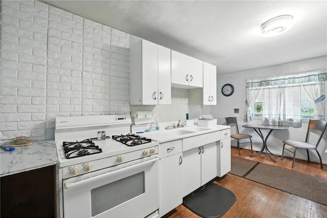 339 E Market St, Mercer Boro, PA 16137 - kitchen featuring white gas range oven, light countertops, dark wood-style flooring, tasteful backsplash, and white cabinetry