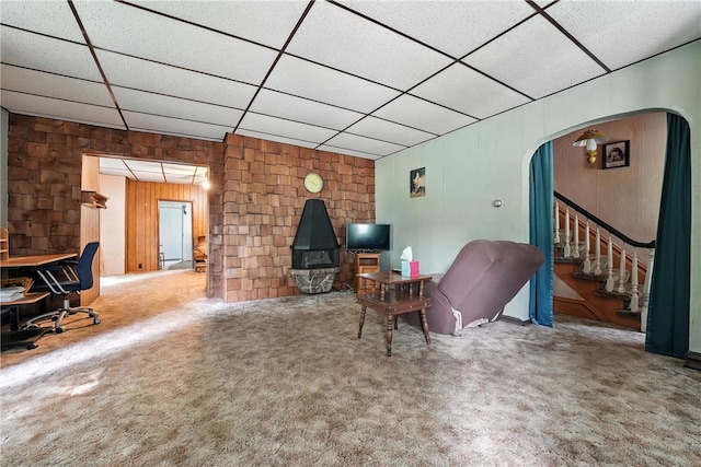 339 E Market St, Mercer Boro, PA 16137 - carpeted living room with a paneled ceiling, stairs, arched walkways, and wood walls