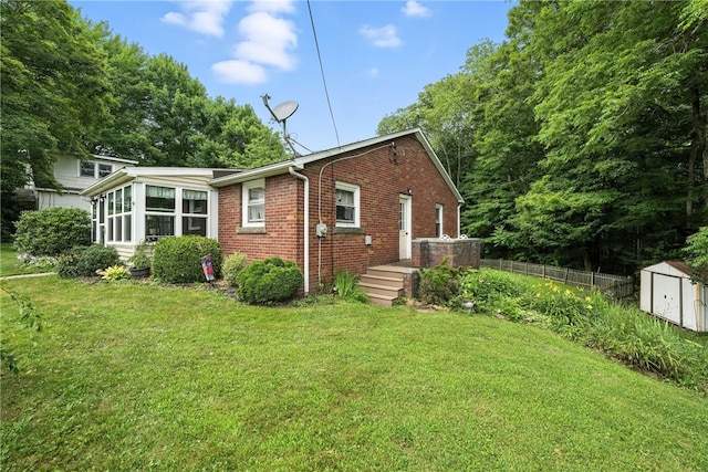 231 E N St, Mercer Boro, PA 16137 - back of house featuring a storage shed, brick siding, and a sunroom