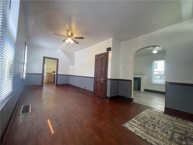 721 Center Ave, City Of But Se, PA 16001 - unfurnished living room featuring ceiling fan, wood finished floors, arched walkways, and a fireplace