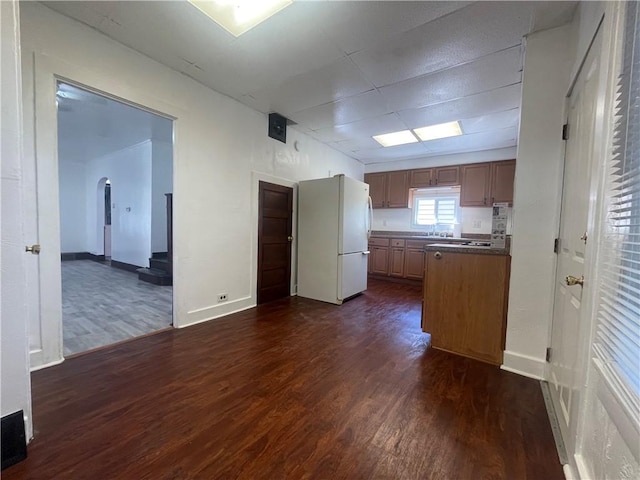 721 Center Ave, City Of But Se, PA 16001 - kitchen featuring freestanding refrigerator, dark wood-type flooring, arched walkways, dark countertops, and a peninsula