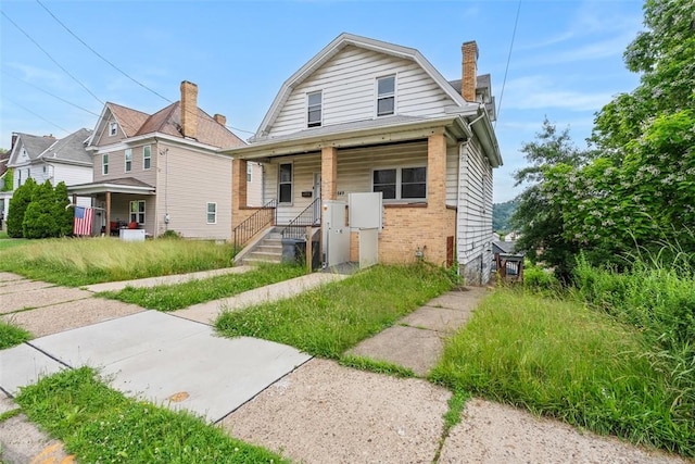 849 Hiland Ave, Coraopolis, PA 15108 - view of front facade with brick siding, a chimney, a gambrel roof, and a porch