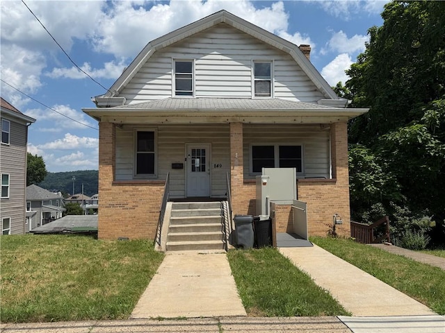 849 Hiland Ave, Coraopolis, PA 15108 - colonial inspired home featuring a gambrel roof, brick siding, a porch, and a front yard