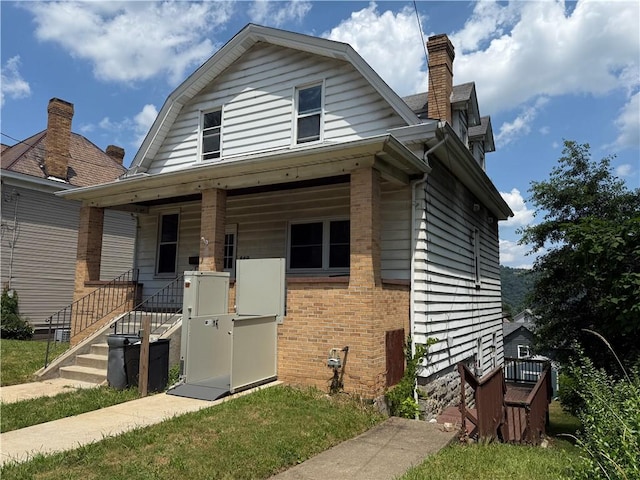 849 Hiland Ave, Coraopolis, PA 15108 - view of front of property with covered porch, a chimney, brick siding, and a gambrel roof