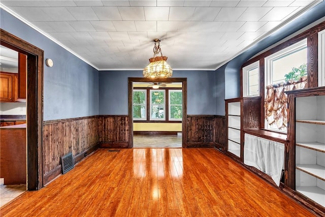 200 38th St, Beaver Falls, PA 15010 - unfurnished dining area with wood walls, wainscoting, hardwood / wood-style floors, ornamental molding, and a chandelier