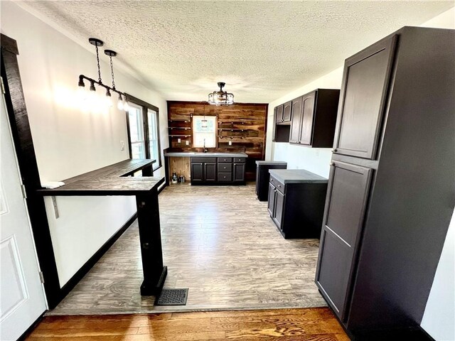 26 Wilmac St, South Union Twp, PA 15401 - kitchen with light wood finished floors, a textured ceiling, decorative light fixtures, and a chandelier