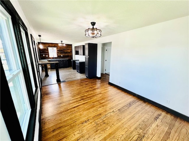 26 Wilmac St, South Union Twp, PA 15401 - kitchen featuring wood finished floors, dark cabinetry, hanging light fixtures, and a chandelier