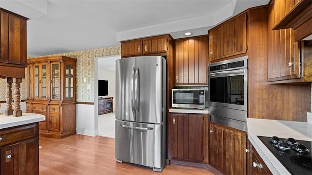 11 Sunnycrest Dr, Cecil, PA 15321 - kitchen with appliances with stainless steel finishes, light countertops, light wood-style flooring, wallpapered walls, and wall chimney range hood