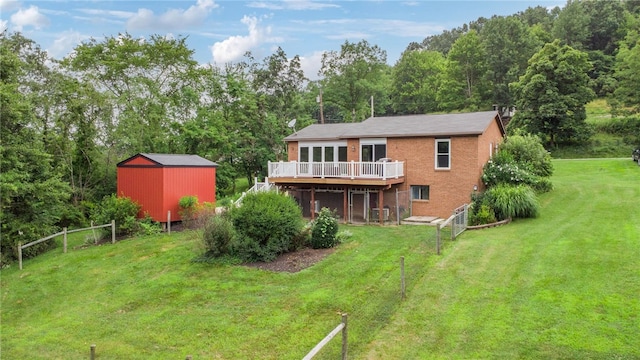 1556 Washington Rd, Washington Twp, PA 15613 - back of property featuring a wooden deck, a storage unit, brick siding, and a wooded view