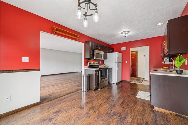 1556 Washington Rd, Washington Twp, PA 15613 - kitchen featuring appliances with stainless steel finishes, dark wood-style floors, light countertops, a chandelier, and a textured ceiling