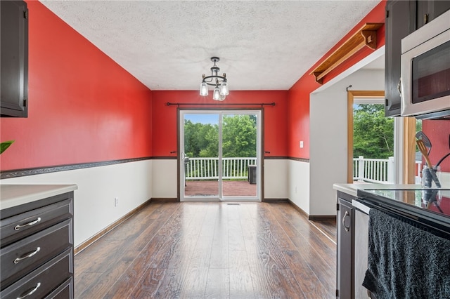 1556 Washington Rd, Washington Twp, PA 15613 - unfurnished dining area with healthy amount of natural light, a chandelier, dark wood-style floors, and a textured ceiling
