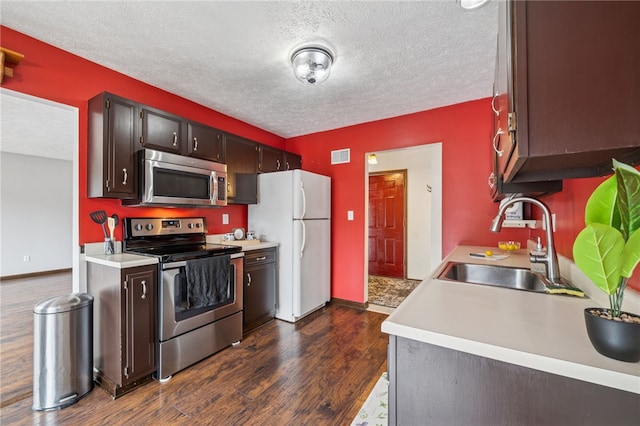 1556 Washington Rd, Washington Twp, PA 15613 - kitchen with appliances with stainless steel finishes, a textured ceiling, light countertops, and dark wood-style floors