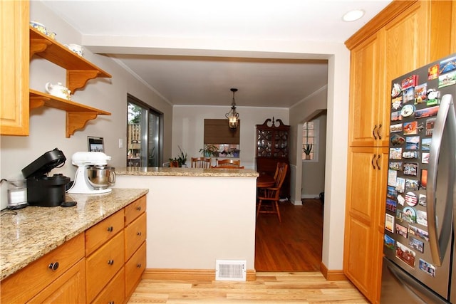 731 Kewanna Ave, Mt Lebanon, PA 15234 - kitchen with freestanding refrigerator, a peninsula, light wood finished floors, light stone counters, and ornamental molding