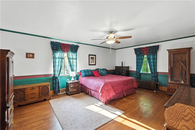 510 7th St, Patterson Heights, PA 15010 - bedroom featuring wood finished floors, radiator heating unit, ceiling fan, a wainscoted wall, and ornamental molding