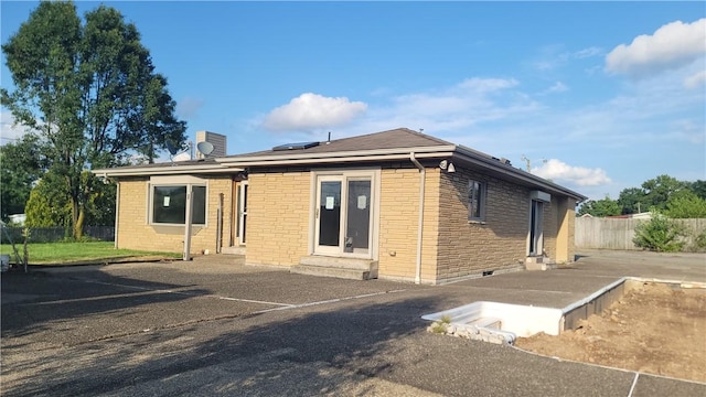 1442 Greensburg Pike, Sewickley Twp, PA 15089 - back of house with brick siding, solar panels, a chimney, and entry steps