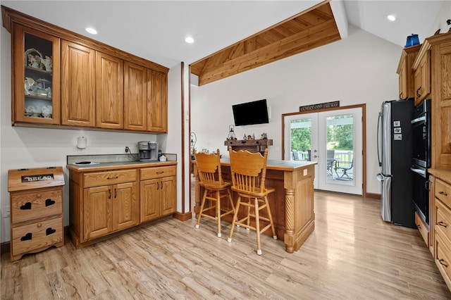 1419 Bullion Rd, Victory Twp, PA 16342 - kitchen with brown cabinets, a peninsula, light wood-style floors, a breakfast bar, and high vaulted ceiling