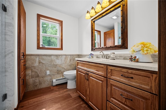 1419 Bullion Rd, Victory Twp, PA 16342 - bathroom featuring tile walls, vanity, wainscoting, wood finished floors, and baseboard heating