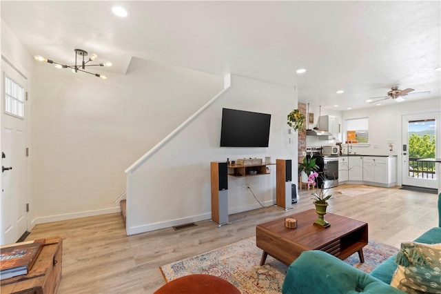 2212 Freeport Rd, Harmar, PA 15238 - living room with light wood-type flooring, stairway, a chandelier, recessed lighting, and ceiling fan