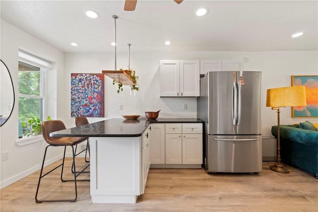 2212 Freeport Rd, Harmar, PA 15238 - kitchen featuring freestanding refrigerator, a peninsula, dark countertops, light wood finished floors, and recessed lighting