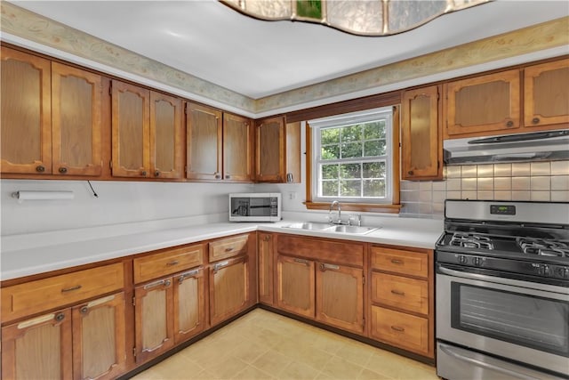 428 Englewood Dr, Ross Twp, PA 15237 - kitchen featuring stainless steel gas stove, under cabinet range hood, light countertops, and brown cabinetry