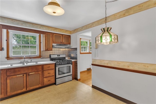 428 Englewood Dr, Ross Twp, PA 15237 - kitchen featuring stainless steel range with gas cooktop, light countertops, brown cabinetry, light flooring, and hanging light fixtures