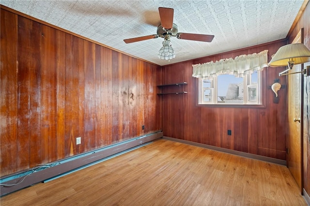 4614 Carroll St, Bloomfield, PA 15224 - spare room with baseboard heating, an ornate ceiling, wood finished floors, ceiling fan, and wooden walls