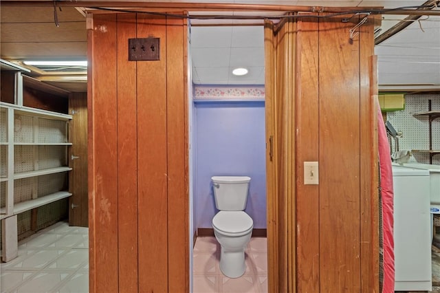 4614 Carroll St, Bloomfield, PA 15224 - bathroom with washer / dryer, wooden walls, and tile patterned floors