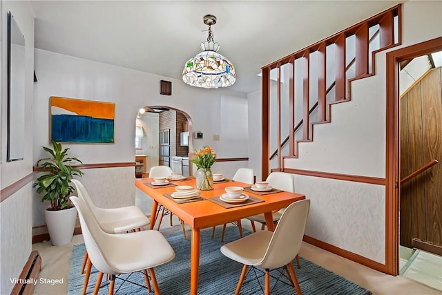 4614 Carroll St, Bloomfield, PA 15224 - dining area with arched walkways, stairway, and a baseboard radiator
