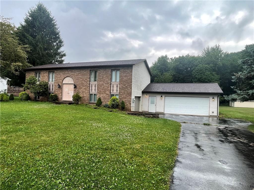 31 Aylesworth Way, Liberty Twp, PA 16127 - split foyer home featuring asphalt driveway, a front lawn, a garage, and brick siding
