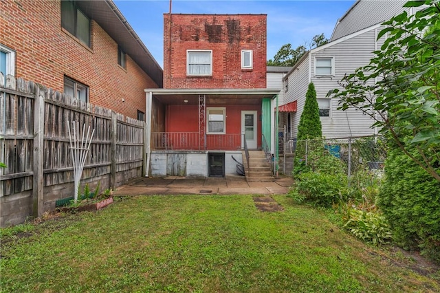 1113 Mary Ann St, South Side, PA 15203 - back of property with brick siding, covered porch, and a fenced backyard