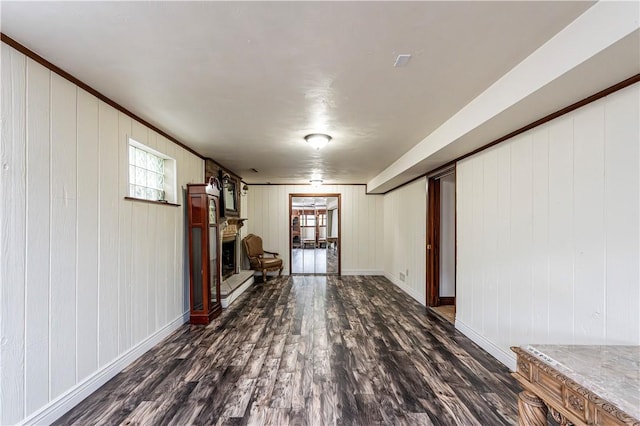 4045 Blue Willow, Hempfield Twp, PA 15642 - living room featuring dark wood-type flooring, a fireplace with raised hearth, wooden walls, and crown molding