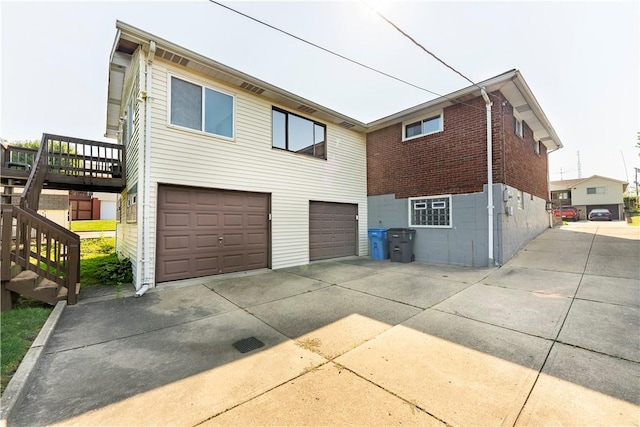 1926 Worcester Dr, Pittsburgh, PA 15243 - back of property with concrete driveway, stairway, an attached garage, and brick siding