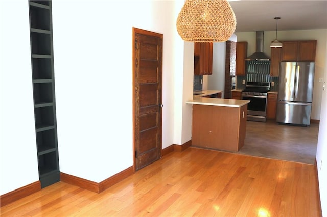 611 Jacksonia St, Central North Side, PA 15212 - kitchen with stainless steel appliances, a peninsula, light countertops, wall chimney exhaust hood, and light wood-type flooring