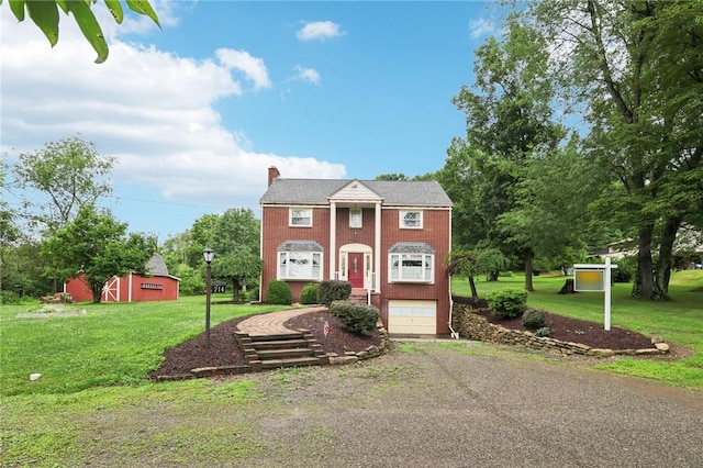 714 Colonial, Washington Twp, PA 15613 - neoclassical home with a garage, a chimney, a front yard, and brick siding