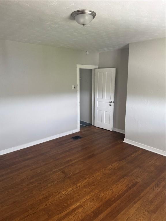 965 Leeds, Monessen, PA 15062 - spare room featuring baseboards and dark wood-type flooring