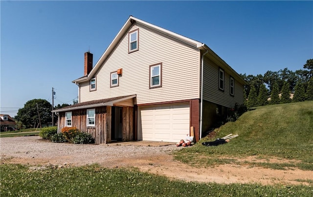 963 Herman Rd, Summit Twp, PA 16002 - rear view of house with an attached garage, a chimney, gravel driveway, and a yard