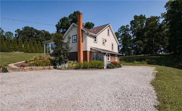 963 Herman Rd, Summit Twp, PA 16002 - view of property exterior featuring gravel driveway, a chimney, a yard, and brick siding
