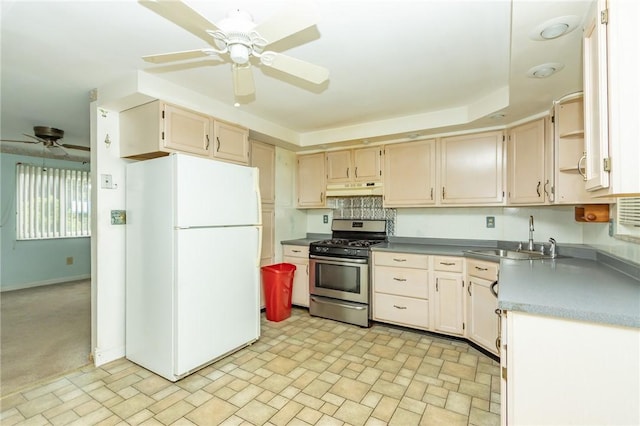 127 Mardi Gras Dr, Plum Boro, PA 15239 - kitchen featuring ceiling fan, freestanding refrigerator, stainless steel gas stove, decorative backsplash, and under cabinet range hood