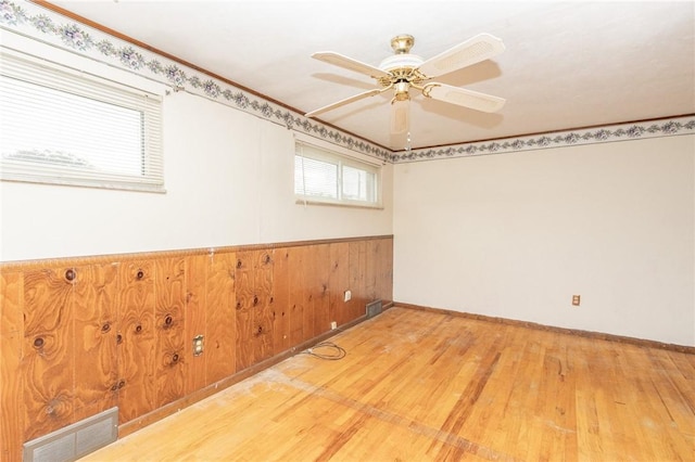 127 Mardi Gras Dr, Plum Boro, PA 15239 - unfurnished room featuring light wood-style flooring, a ceiling fan, wainscoting, and wood walls