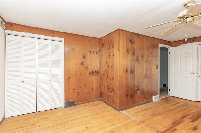 127 Mardi Gras Dr, Plum Boro, PA 15239 - unfurnished bedroom featuring wood finished floors, wooden walls, a closet, and ceiling fan