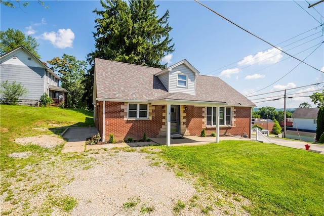 57 Welcome St, East Bethlehem, PA 15333 - cape cod house with brick siding, roof with shingles, a front yard, and a patio