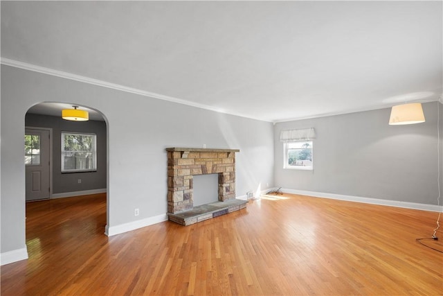 57 Welcome St, East Bethlehem, PA 15333 - unfurnished living room featuring crown molding, wood finished floors, a fireplace, and arched walkways
