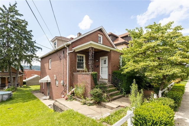 827 Beaver Rd, Ambridge, PA 15003 - view of front of home with brick siding, a front lawn, and a chimney