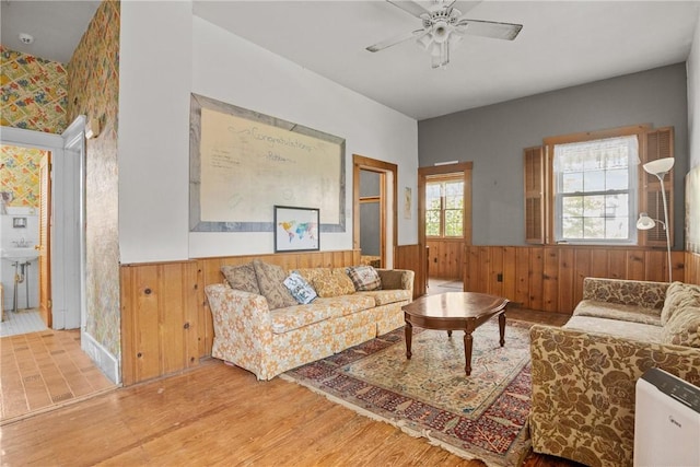 827 Beaver Rd, Ambridge, PA 15003 - living area featuring a wainscoted wall, wooden walls, ceiling fan, and wood finished floors